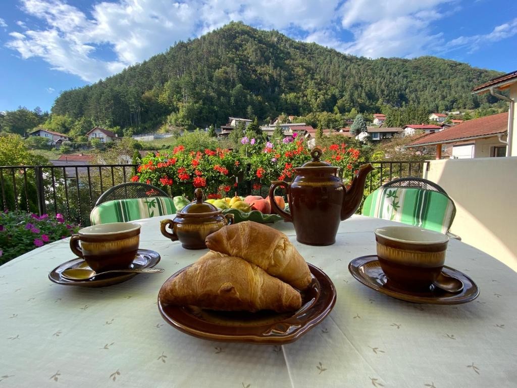 Cozy breakfast with croissants and coffee overlooking a mountain village.