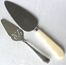 Two vintage cake servers with decorative handles on white surface.