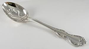 Elegant silver spoon with ornate handle design.