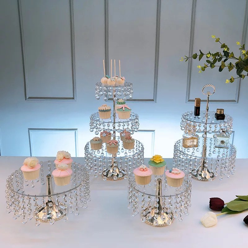 Elegant dessert display with cupcakes and candles on tiered stands.