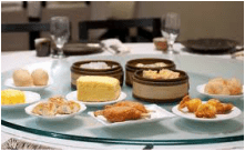 A variety of dim sum dishes served on a round table.