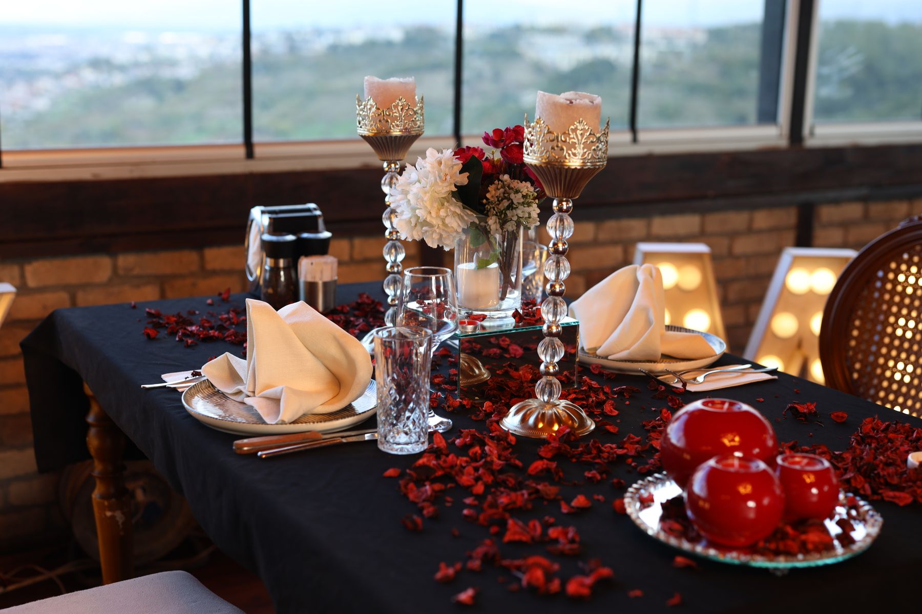 Candlelit date-night table with a cocktail and playing cards