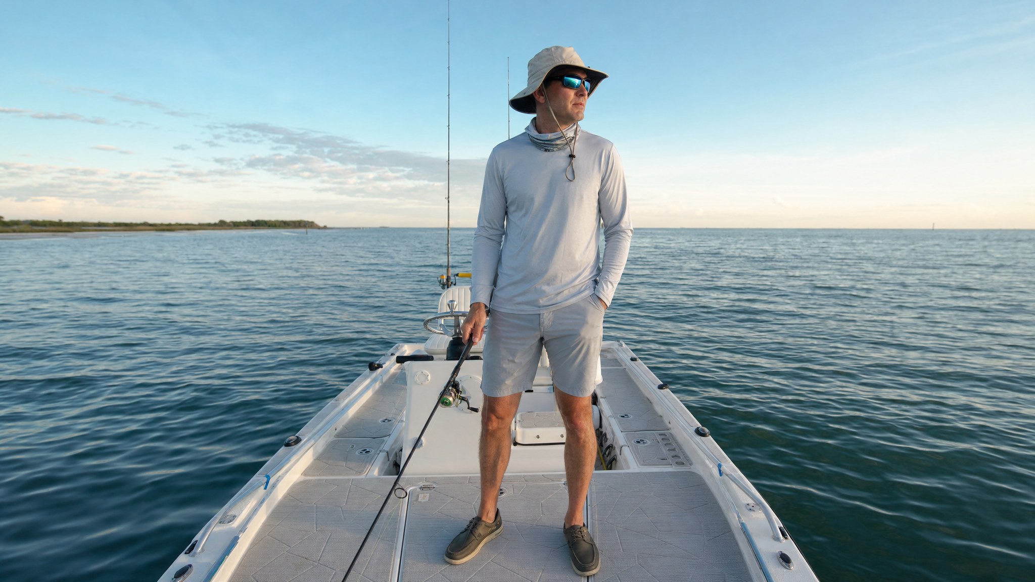 Angler in a sun shirt, brimmed hat, shorts, and deck shoes on a charter boat