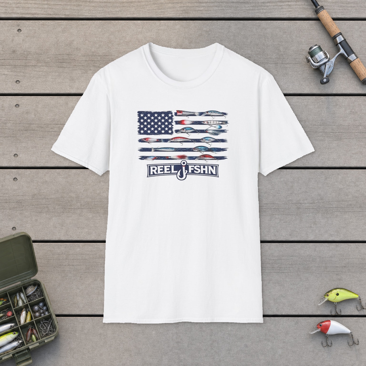 American Flag Lures T-Shirt on a wooden dock with a fishing rod, reel, tackle box, and two lures