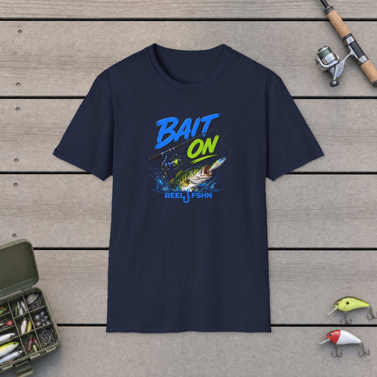 Bait On with Rod & Reel  T-Shirt on a wooden dock with a fishing rod, reel, tackle box, and two lures