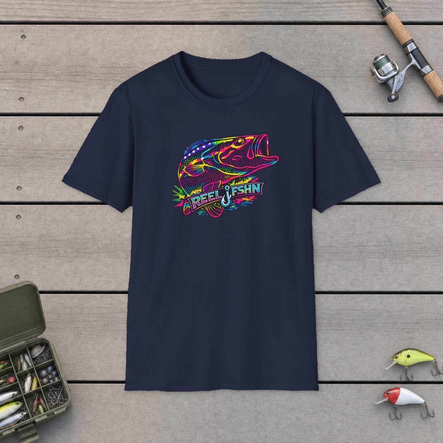 Funky Bass with REEL FSHN Logo T-Shirt on a wooden dock with a fishing rod, reel, tackle box, and two lures