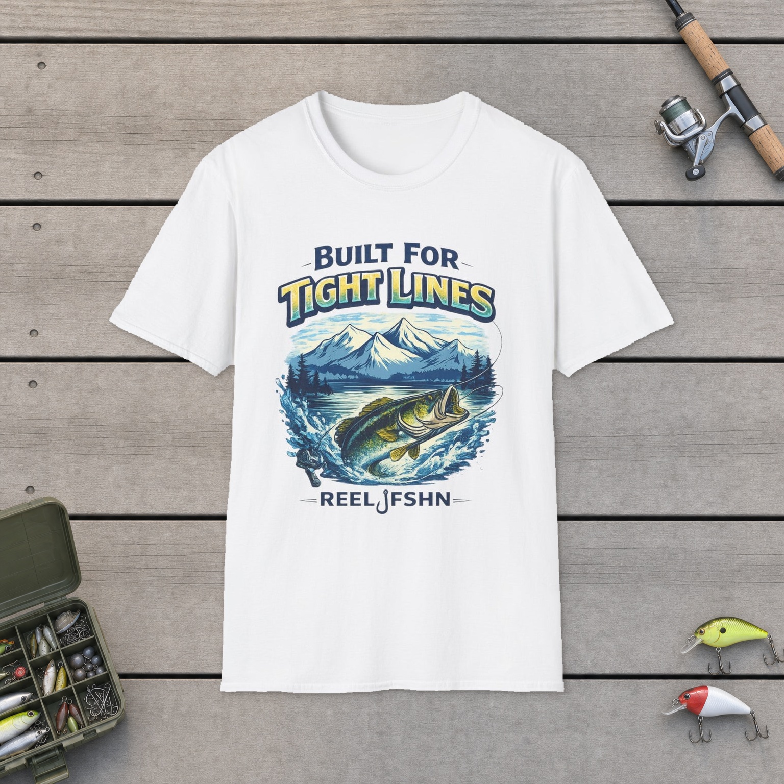 "Built for Tight Lines" T-Shirt on a wooden dock with a fishing rod, reel, tackle box, and two lures