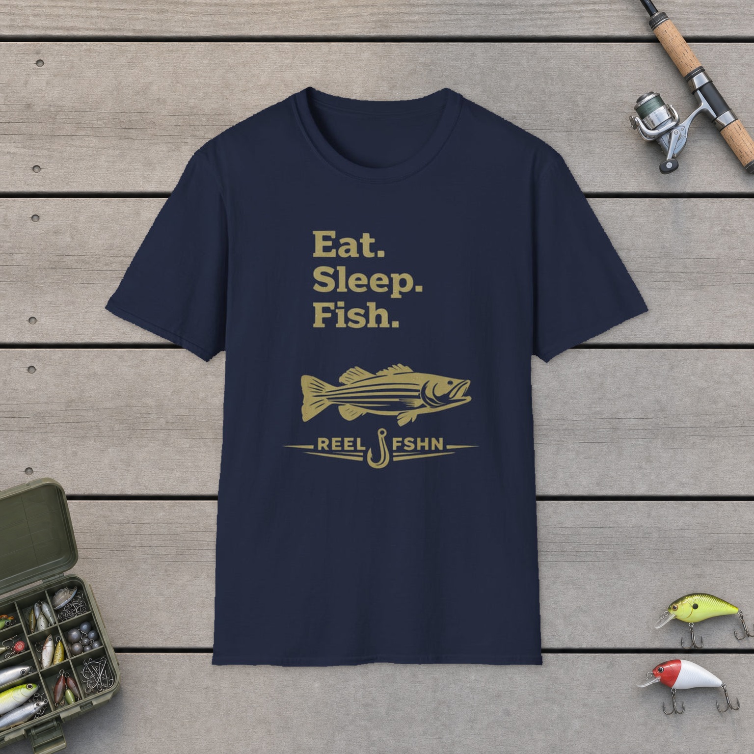 Eat. Sleep. Fish. T-Shirt on a wooden dock with a fishing rod, reel, tackle box, and two lures