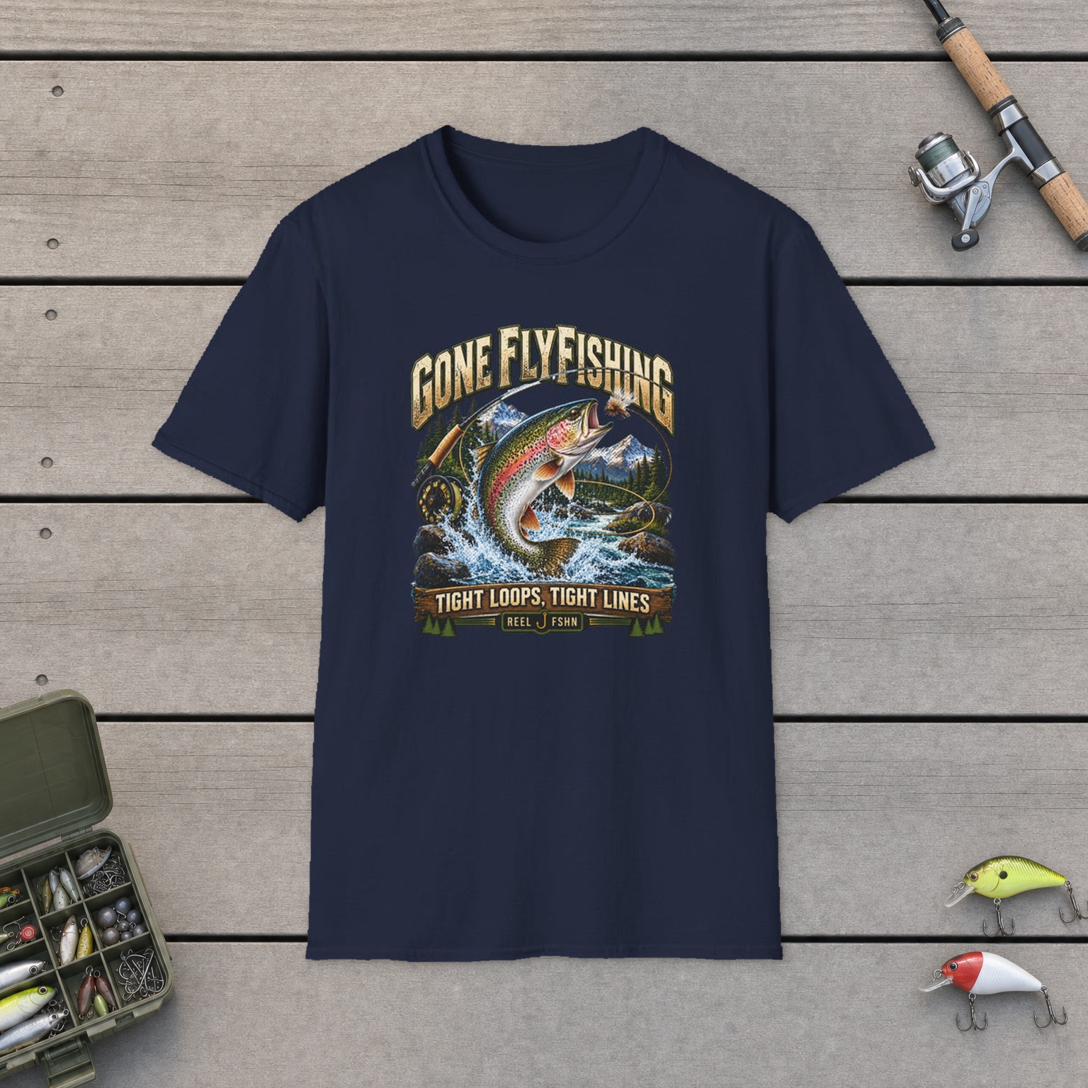 Gone Fly Fishing T-Shirt on a wooden dock with a fishing rod, reel, tackle box, and two lures