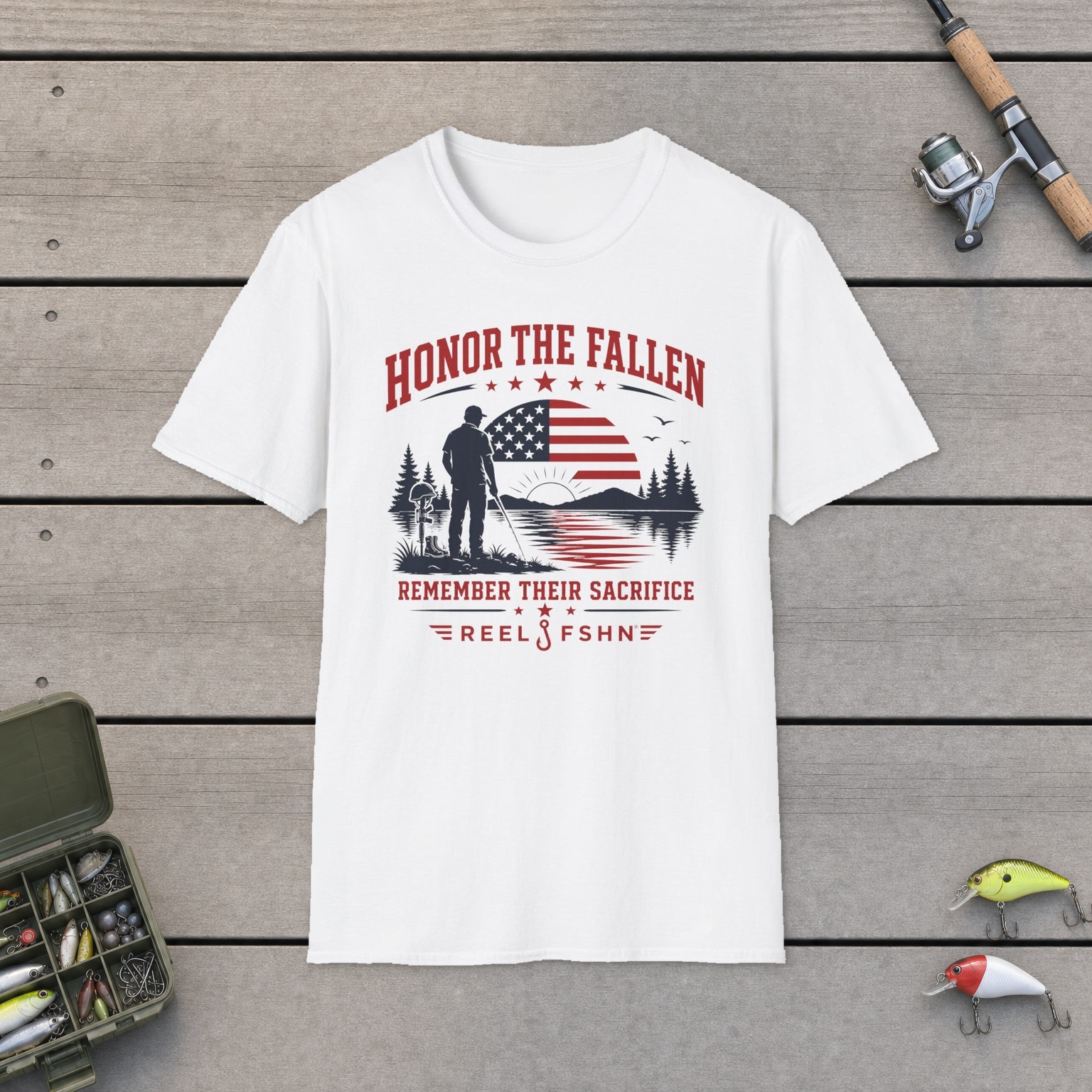 Honor The Fallen Remember Their Sacrifice T-Shirt on a wooden dock with a fishing rod, reel, tackle box, and two lures