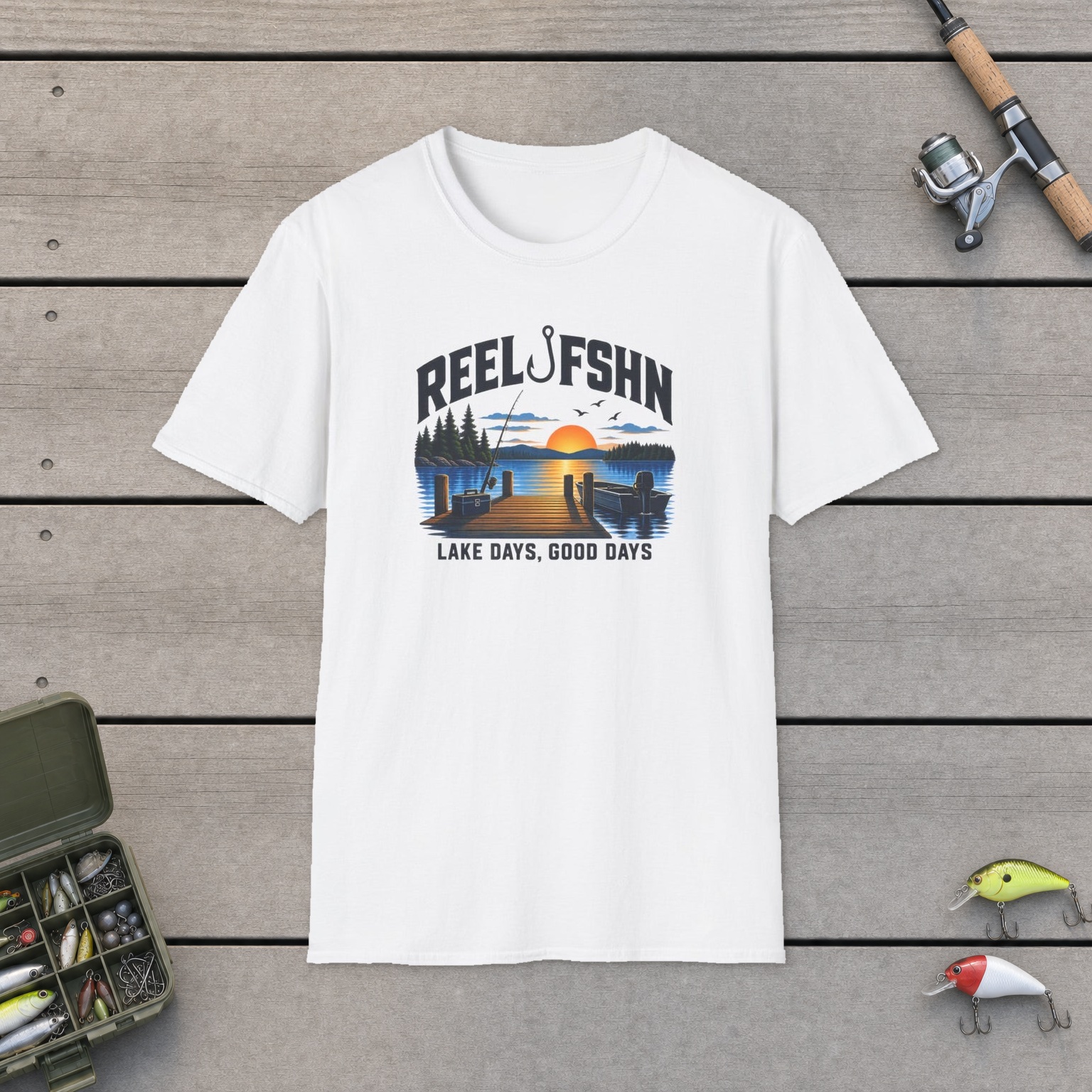 Lake Days Good Days T-Shirt on a wooden dock with a fishing rod, reel, tackle box, and two lures