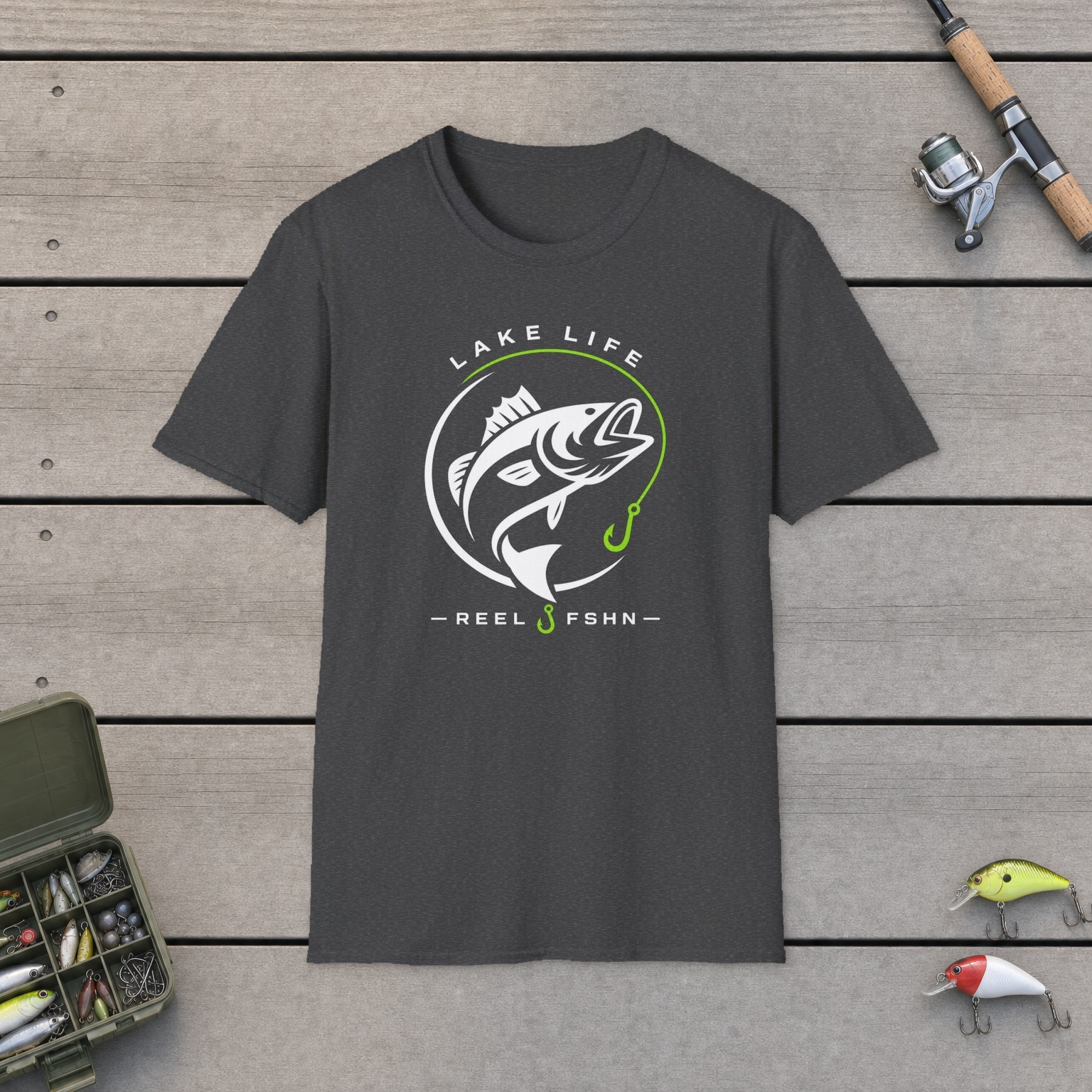 Lake Life T-Shirt on a wooden dock with a fishing rod, reel, tackle box, and two lures