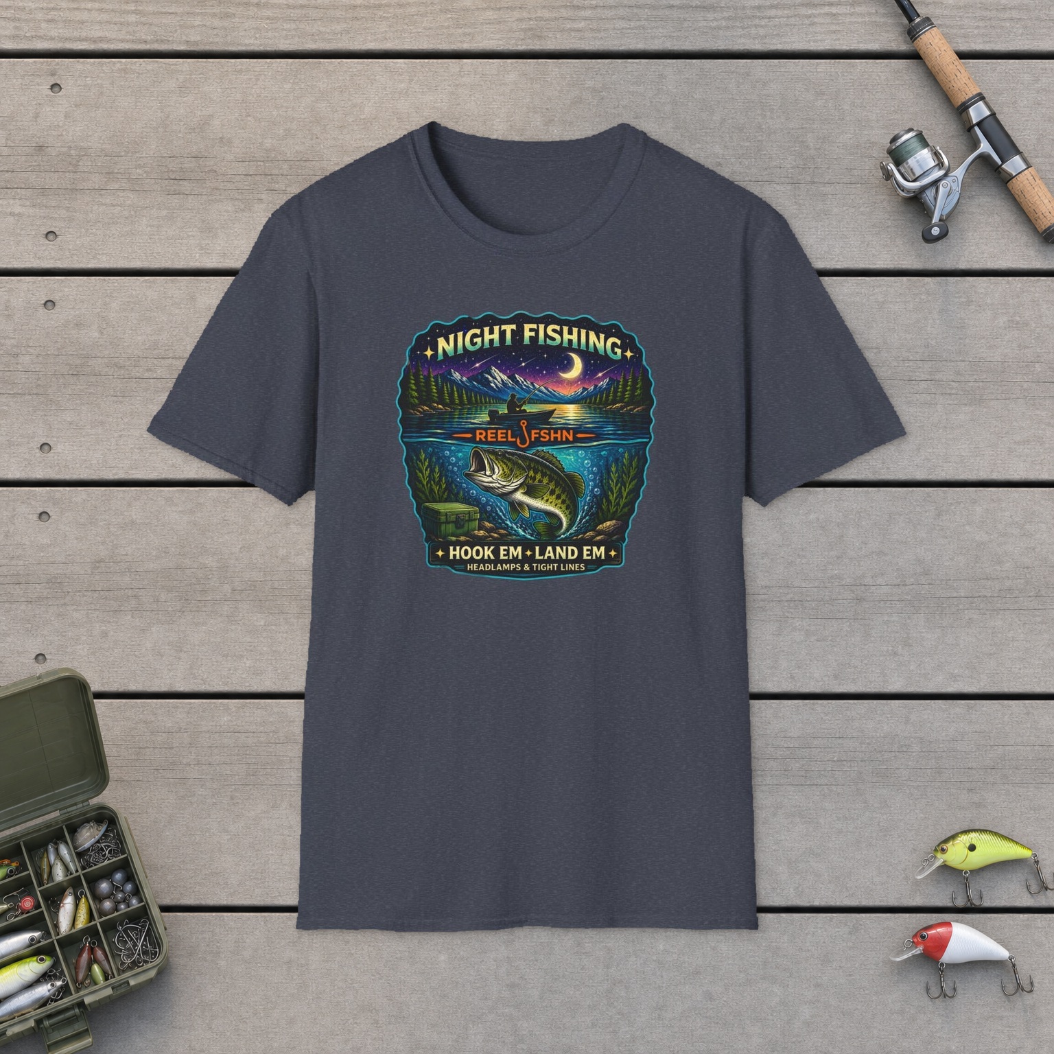 Night Fishing T-Shirt on a wooden dock with a fishing rod, reel, tackle box, and two lures