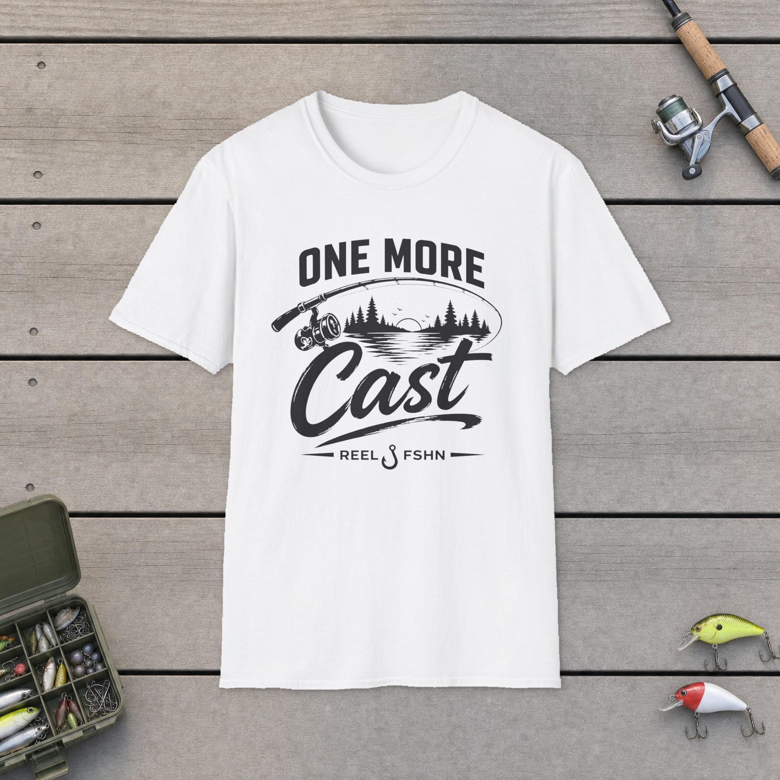 One More Cast T-Shirt on a wooden dock with a fishing rod, reel, tackle box, and two lures