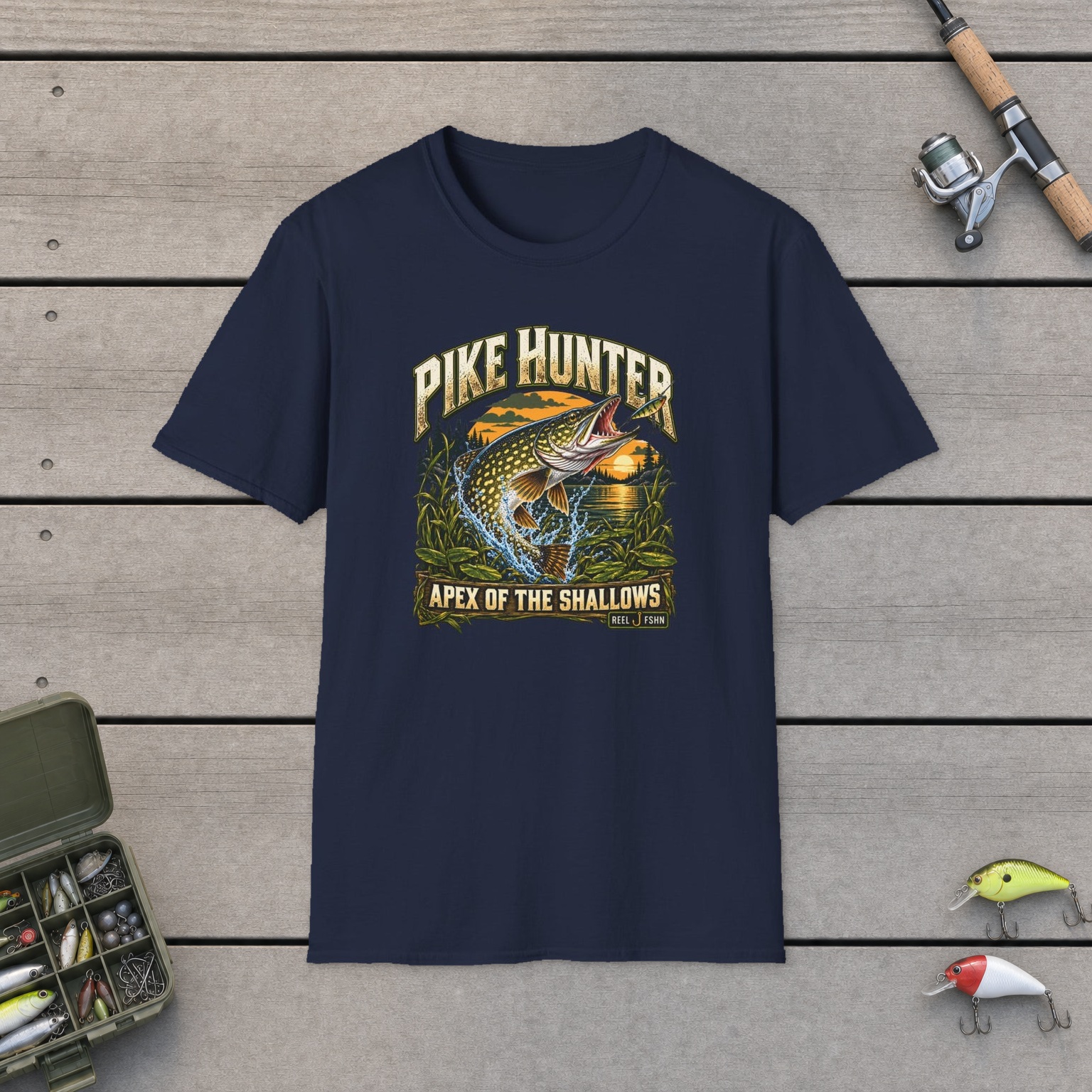 Pike Hunter T-Shirt on a wooden dock with a fishing rod, reel, tackle box, and two lures