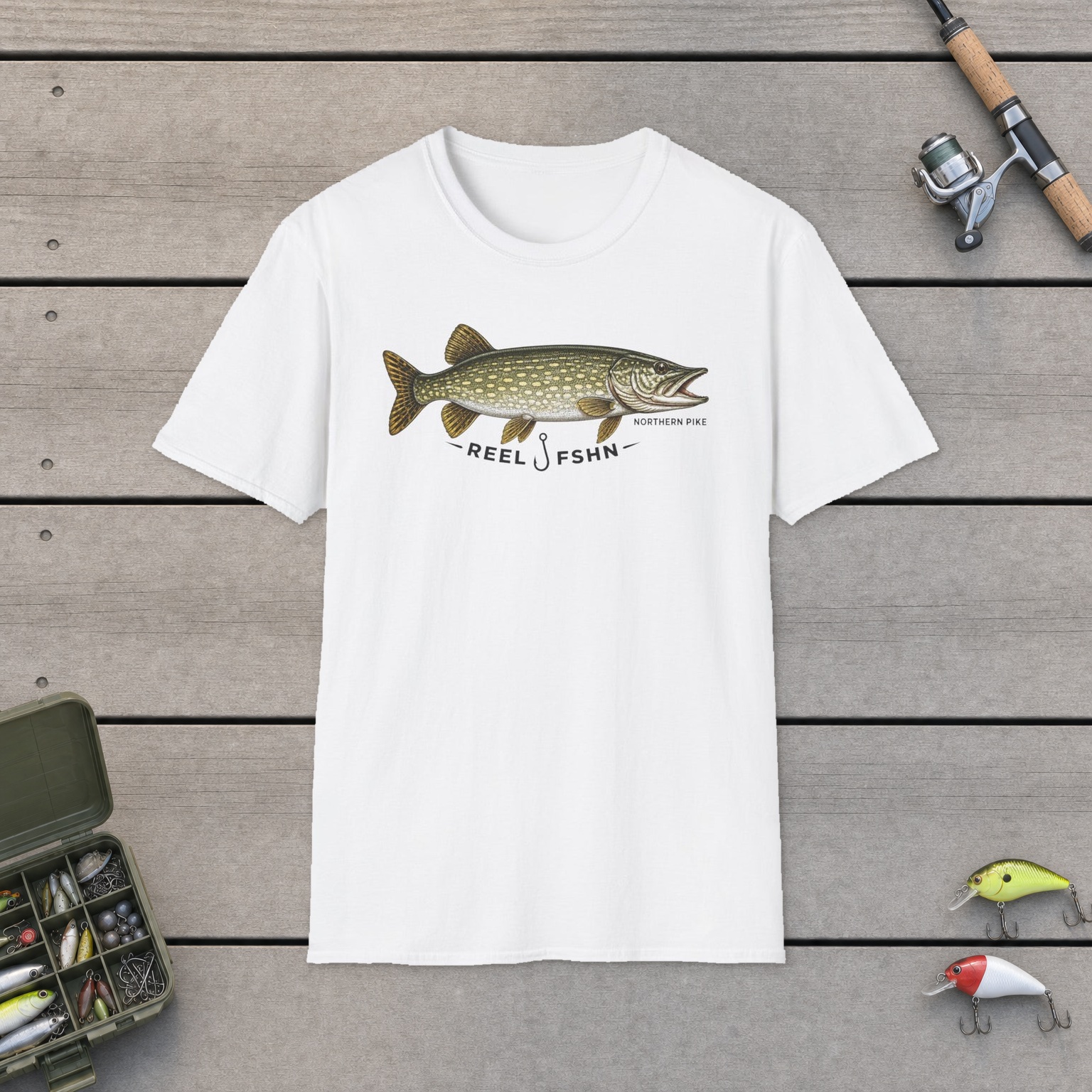 REEL FSHN NORTHERN PIKE T-Shirt on a wooden dock with a fishing rod, reel, tackle box, and two lures