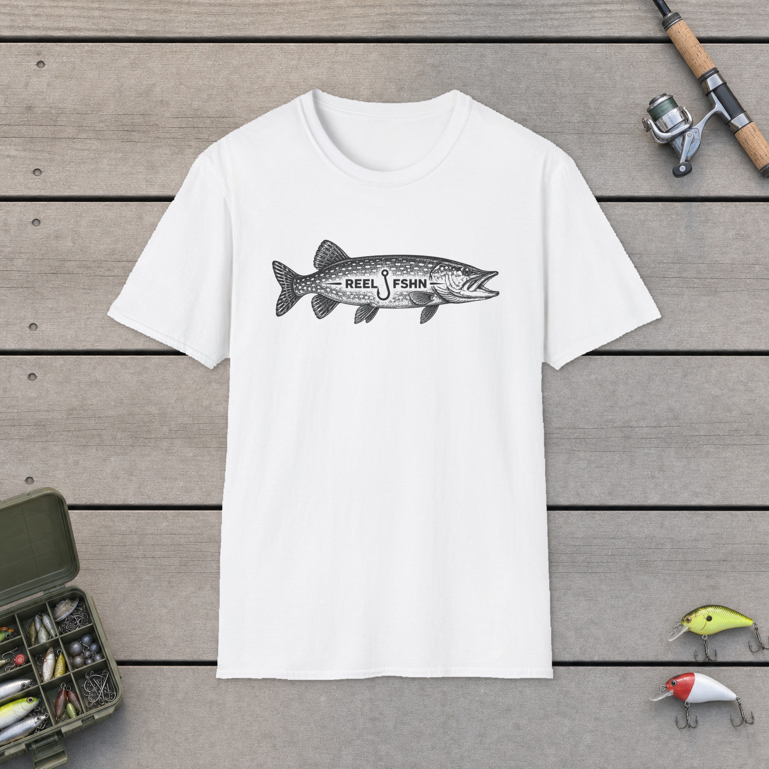 REEL FSHN PIKE T-Shirt on a wooden dock with a fishing rod, reel, tackle box, and two lures