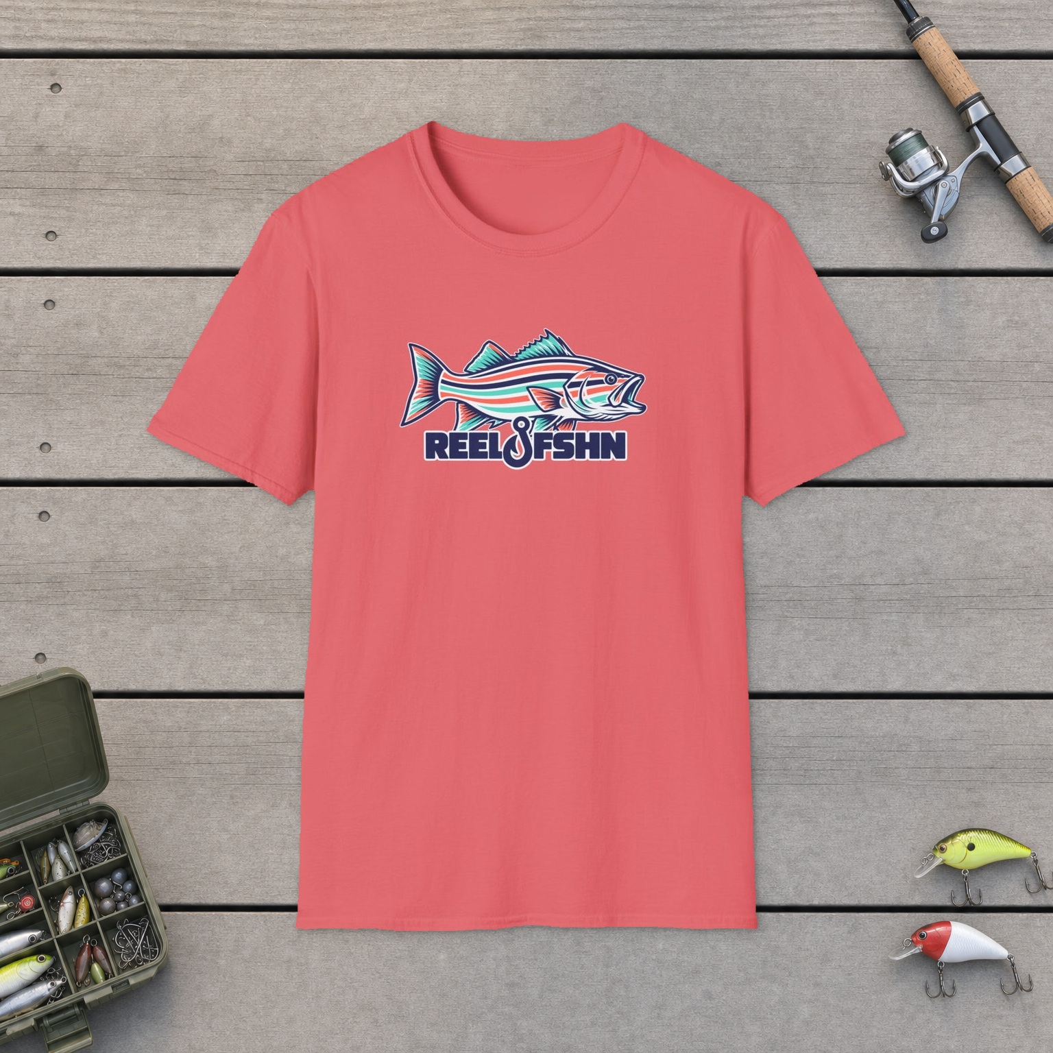 Striped Seafoam Bass T-Shirt on a wooden dock with a fishing rod, reel, tackle box, and two lures
