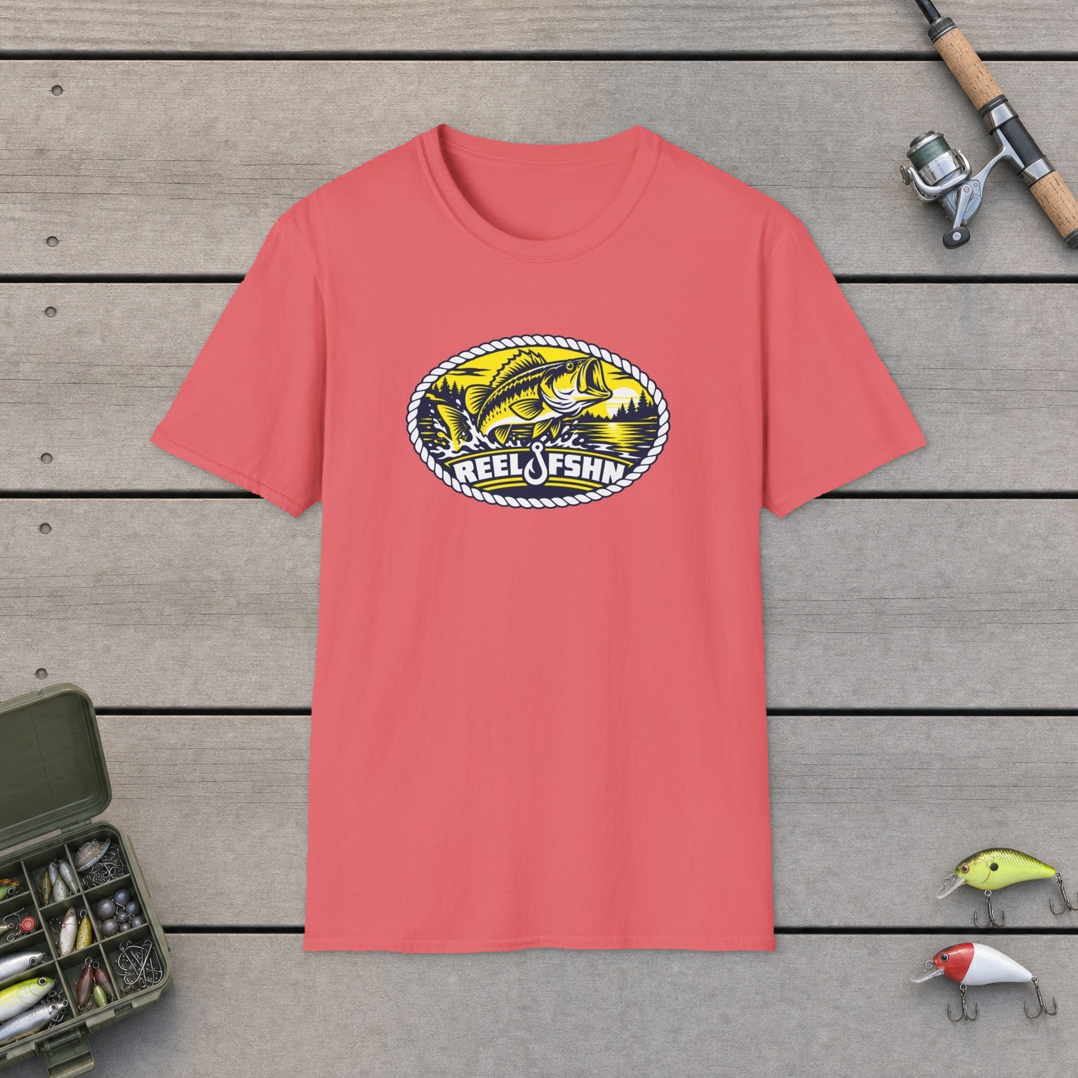 Yellow Bass Badge T-Shirt on a wooden dock with a fishing rod, reel, tackle box, and two lures
