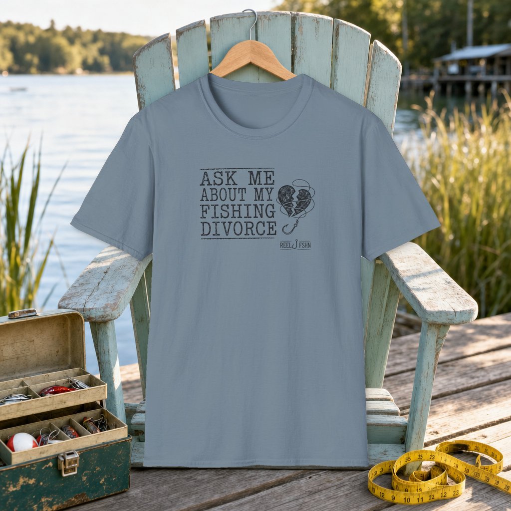 Ask Me About My Fishing Divorce T-Shirt on a hanger on a seafoam fishing chair beside a lake, tackle box, and measuring tape