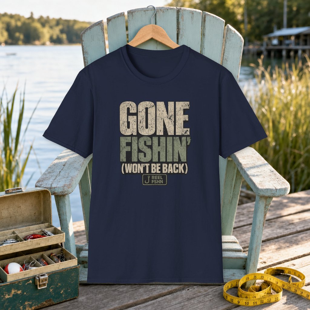 Gone Fishin Won't Be Back T-Shirt on a hanger on a seafoam fishing chair beside a lake, tackle box, and measuring tape