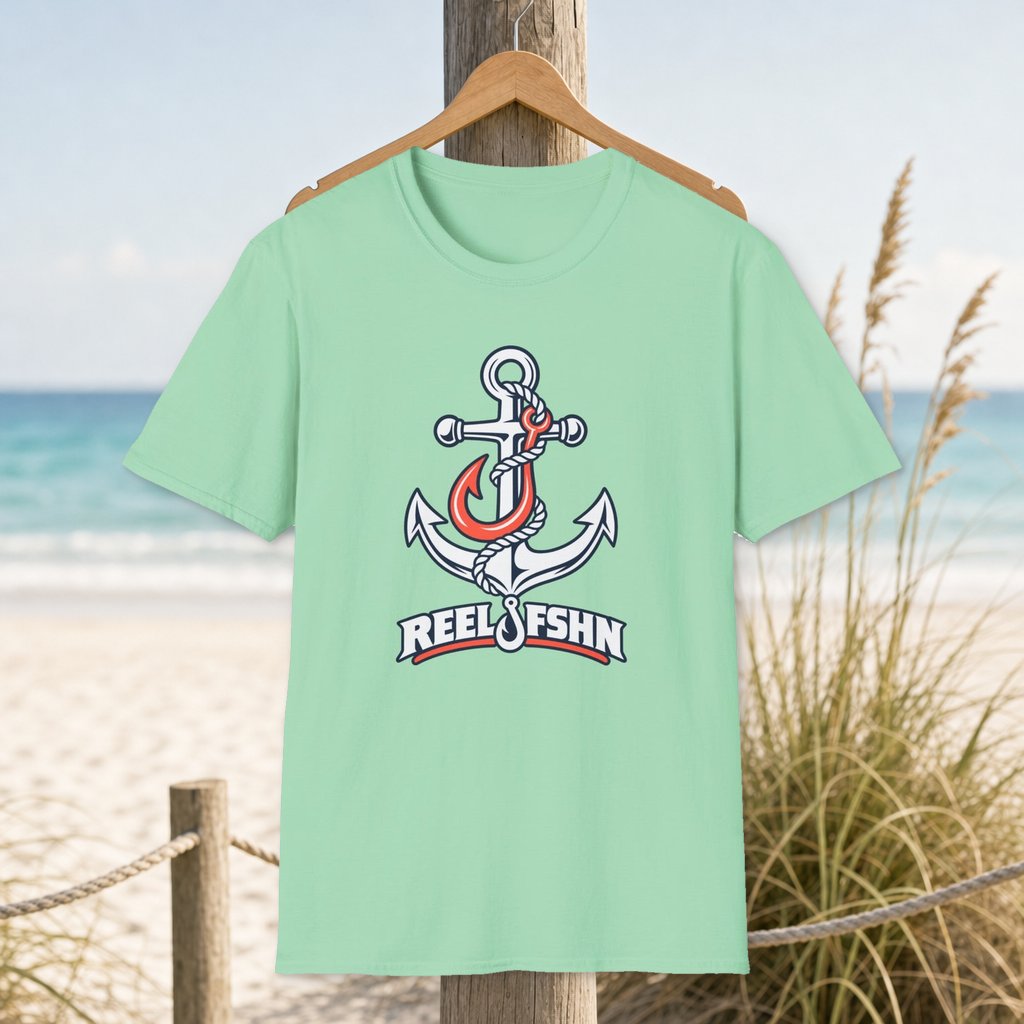 Coral & White Anchor T-Shirt on a hanger beside a sandy beach and turquoise coastal water