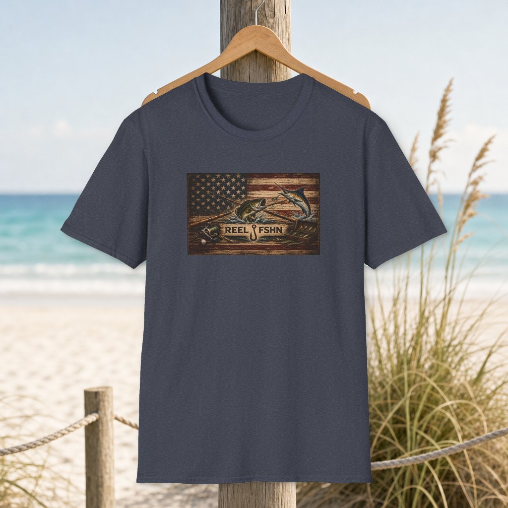 American Flag With Bass and Marlin T-Shirt on a hanger beside a sandy beach and turquoise coastal water