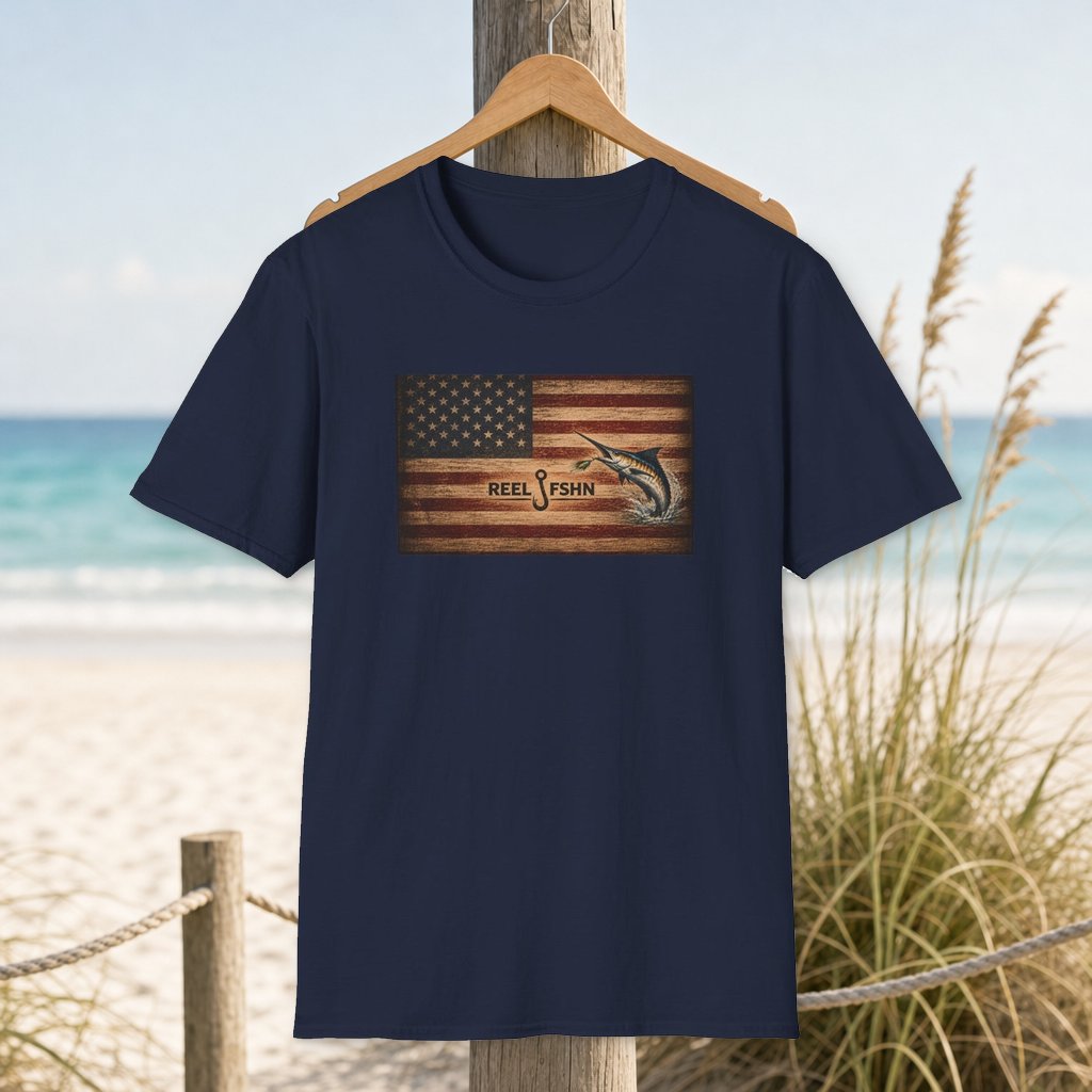 American Flag With Marlin T-Shirt on a hanger beside a sandy beach and turquoise coastal water