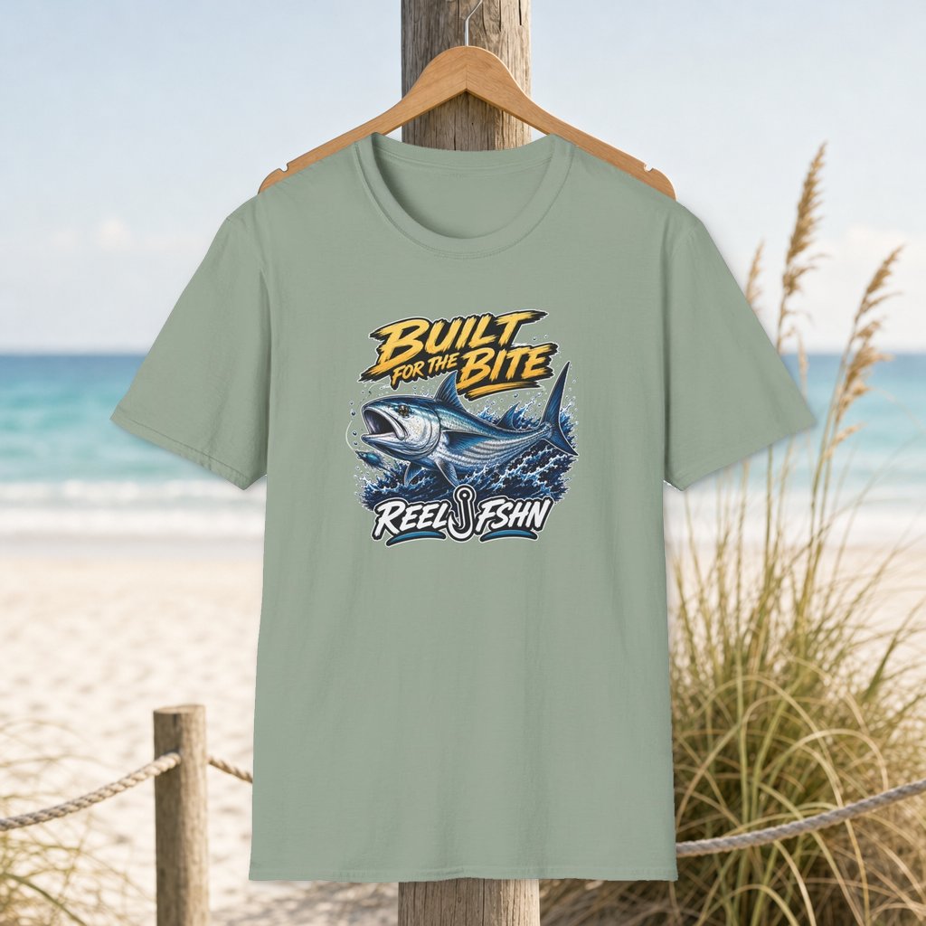 Built For The Bite T-Shirt on a hanger beside a sandy beach and turquoise coastal water