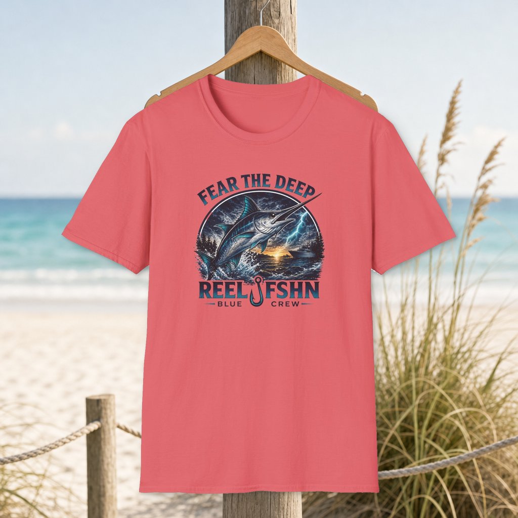 Fear The Deep T-Shirt on a hanger beside a sandy beach and turquoise coastal water