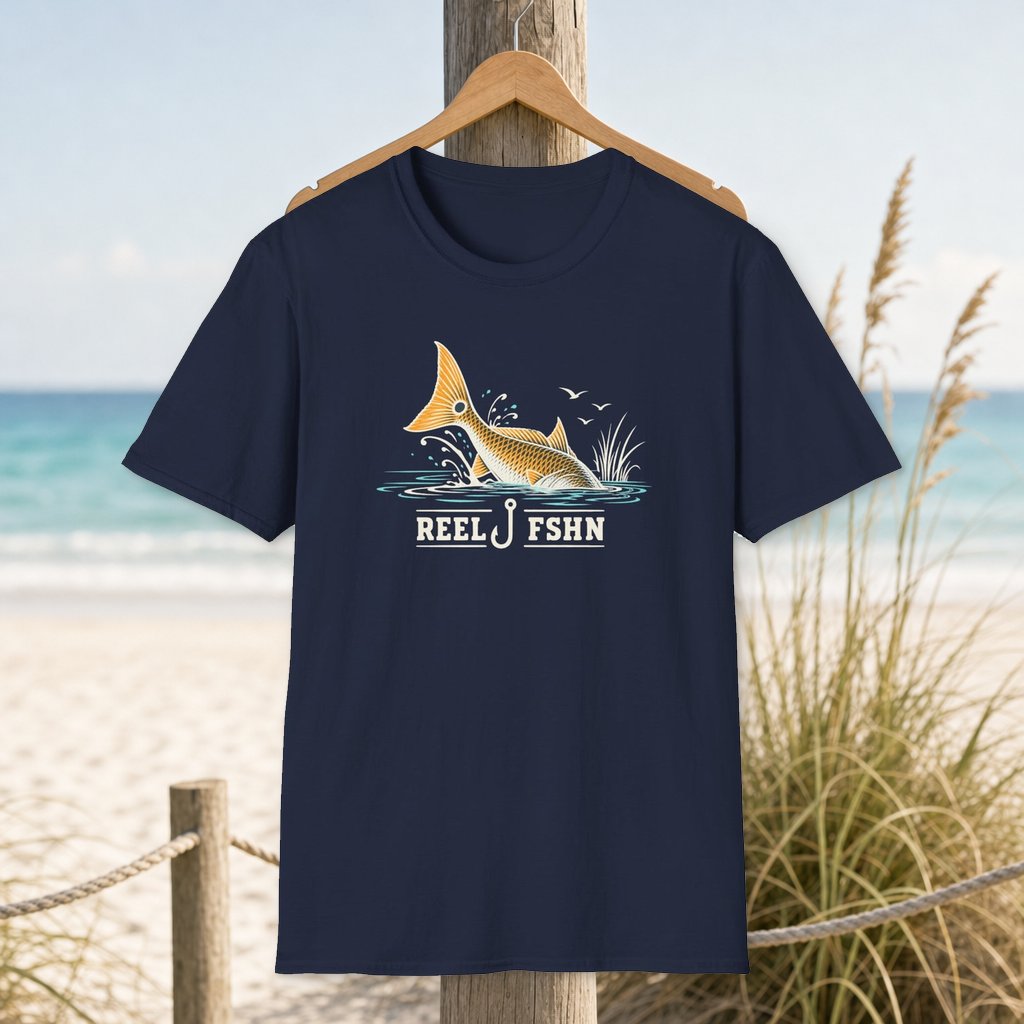 Fish Tail Flip T-Shirt on a hanger beside a sandy beach and turquoise coastal water