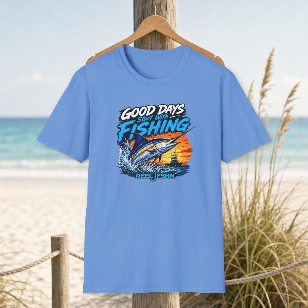 Good Days Start With Fishing Marlin T-Shirt on a hanger beside a sandy beach and turquoise coastal water