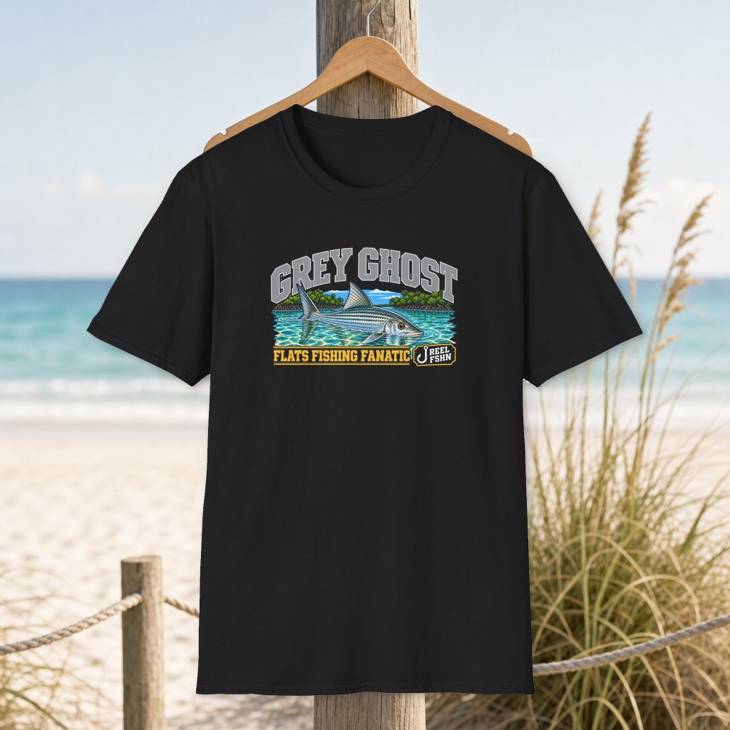 Grey Ghost T-Shirt on a hanger beside a sandy beach and turquoise coastal water