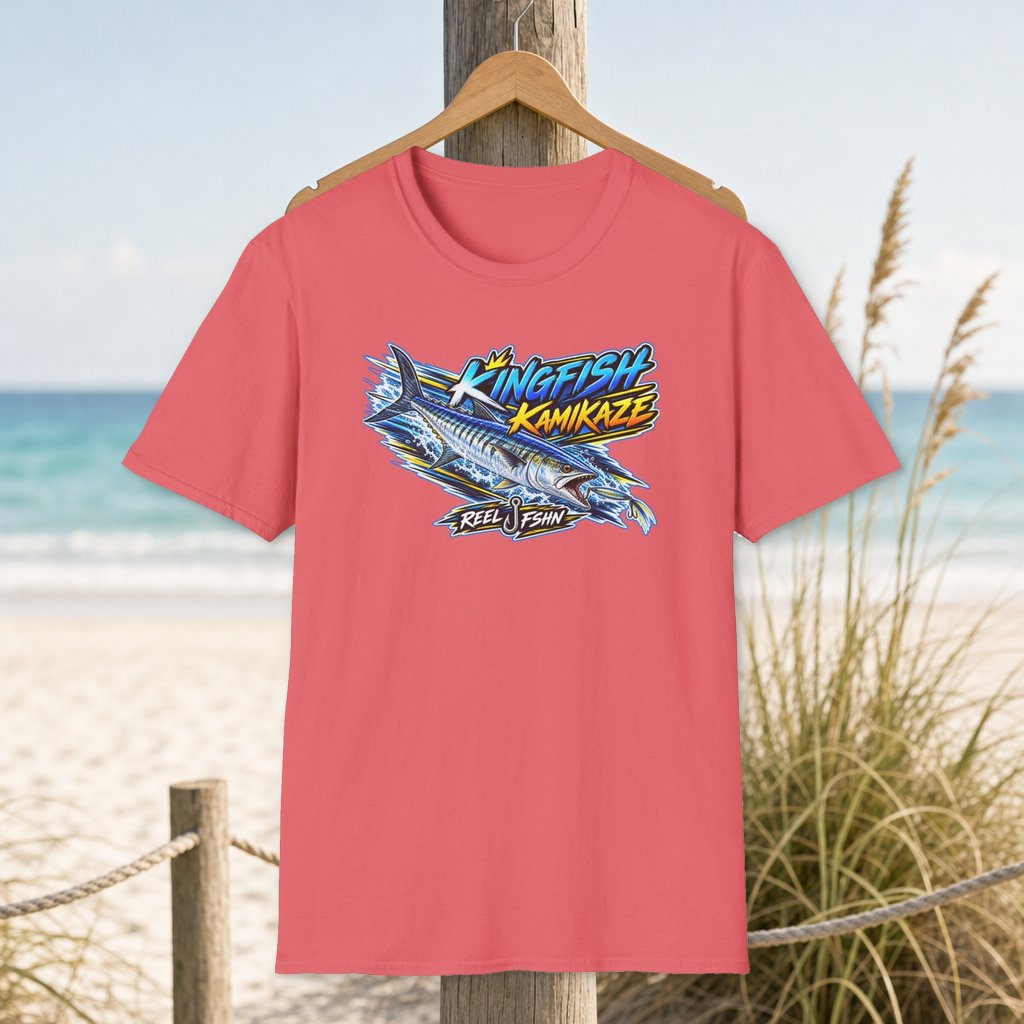 Kingfish Kamikaze T-Shirt on a hanger beside a sandy beach and turquoise coastal water