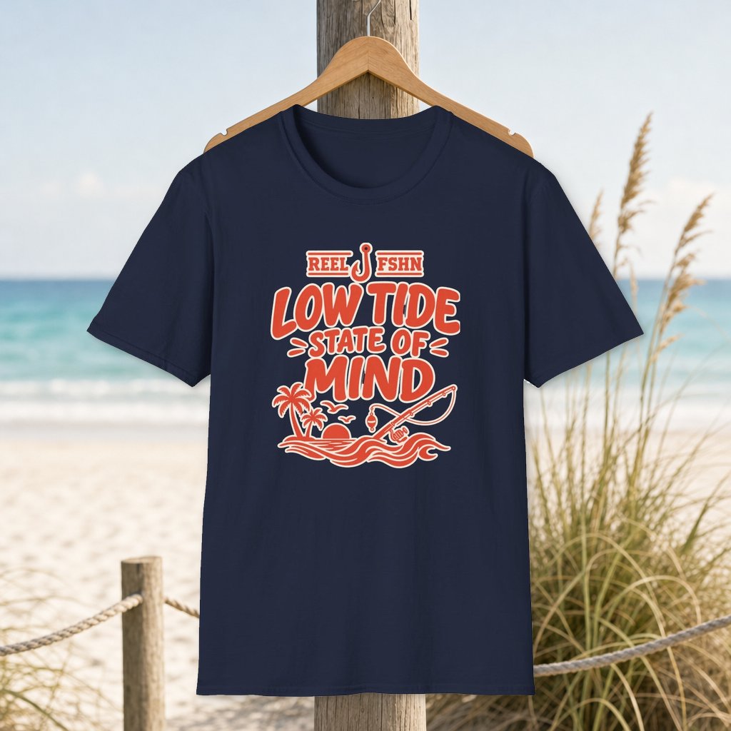 Low Tide State of Mind T-Shirt on a hanger beside a sandy beach and turquoise coastal water