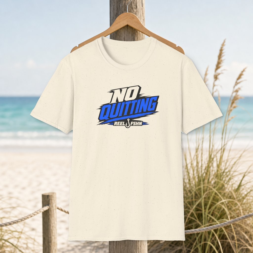 No Quitting T-Shirt on a hanger beside a sandy beach and turquoise coastal water
