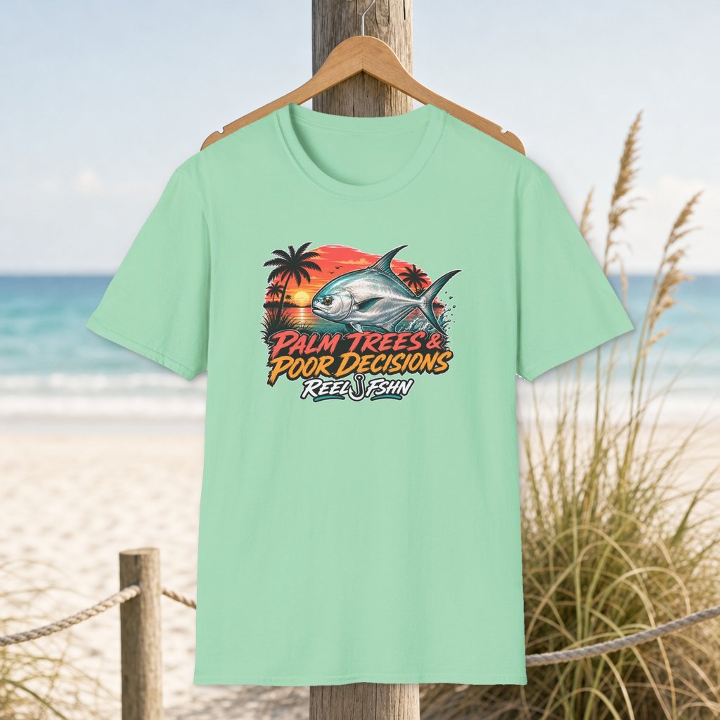 Palm Trees & Poor Decisions T-Shirt on a hanger beside a sandy beach and turquoise coastal water