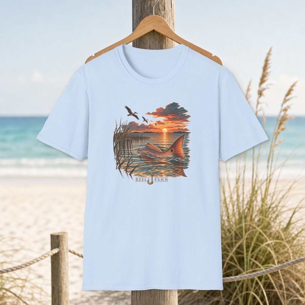 Redfish At Dusk T-Shirt on a hanger beside a sandy beach and turquoise coastal water