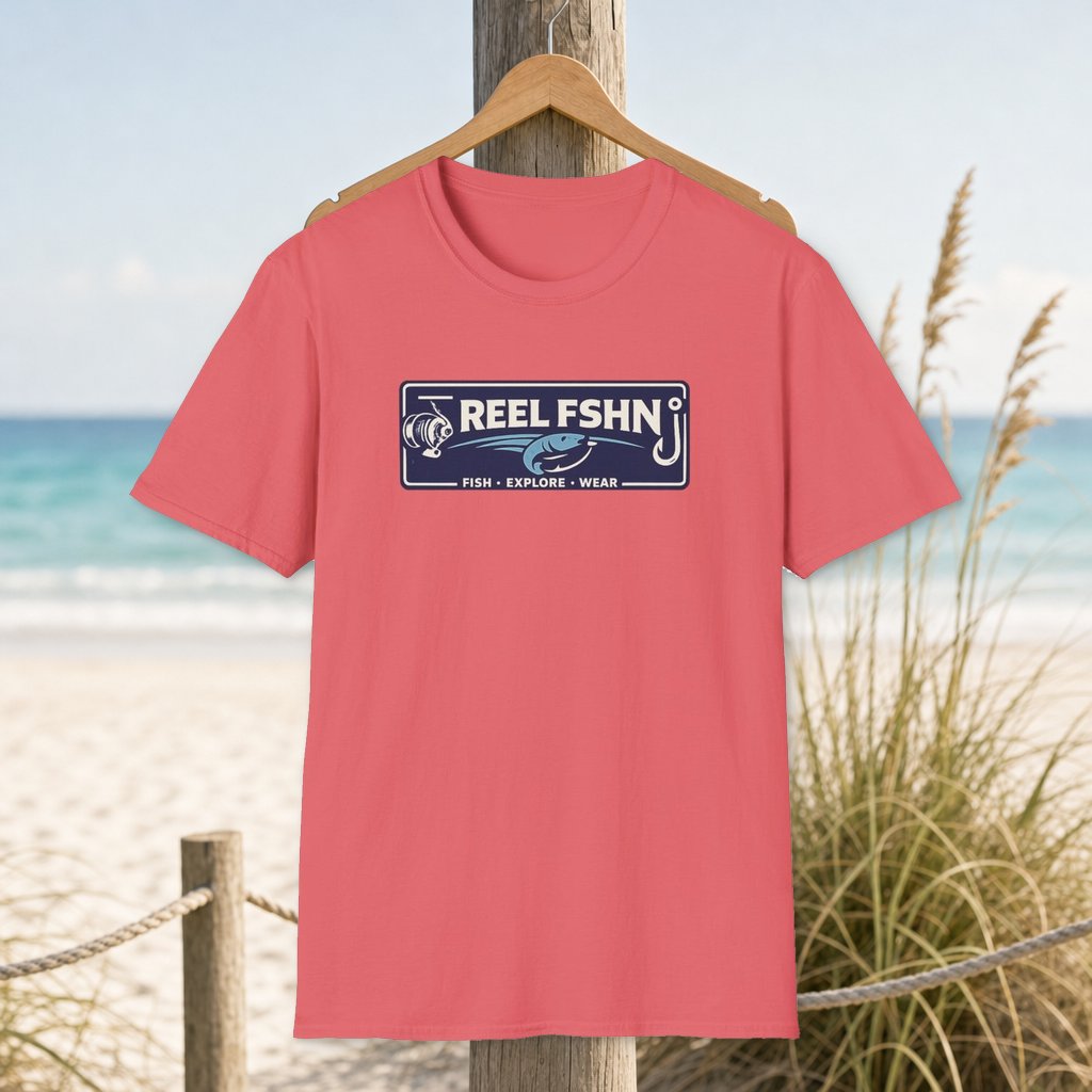 Reel FSHN Logo T-Shirt on a hanger beside a sandy beach and turquoise coastal water