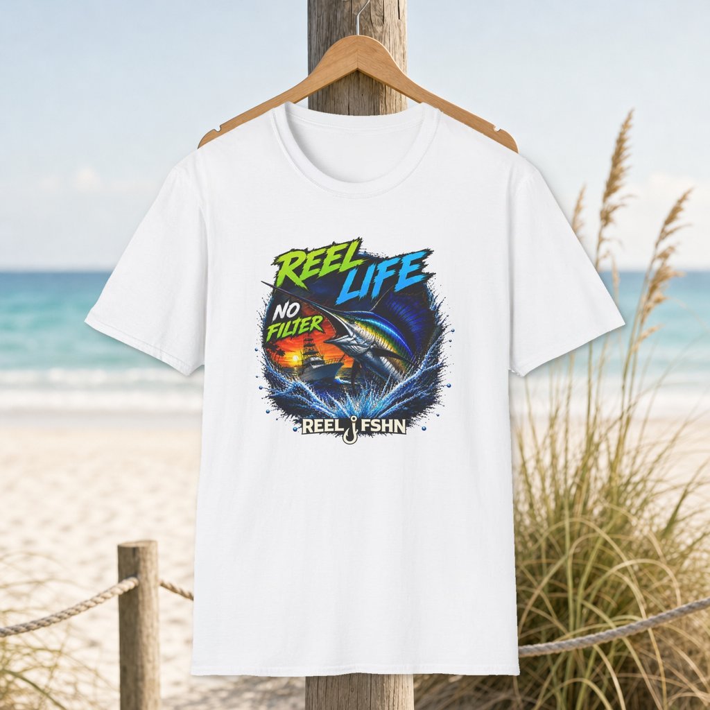 REEL Life No Filter T-Shirt on a hanger beside a sandy beach and turquoise coastal water