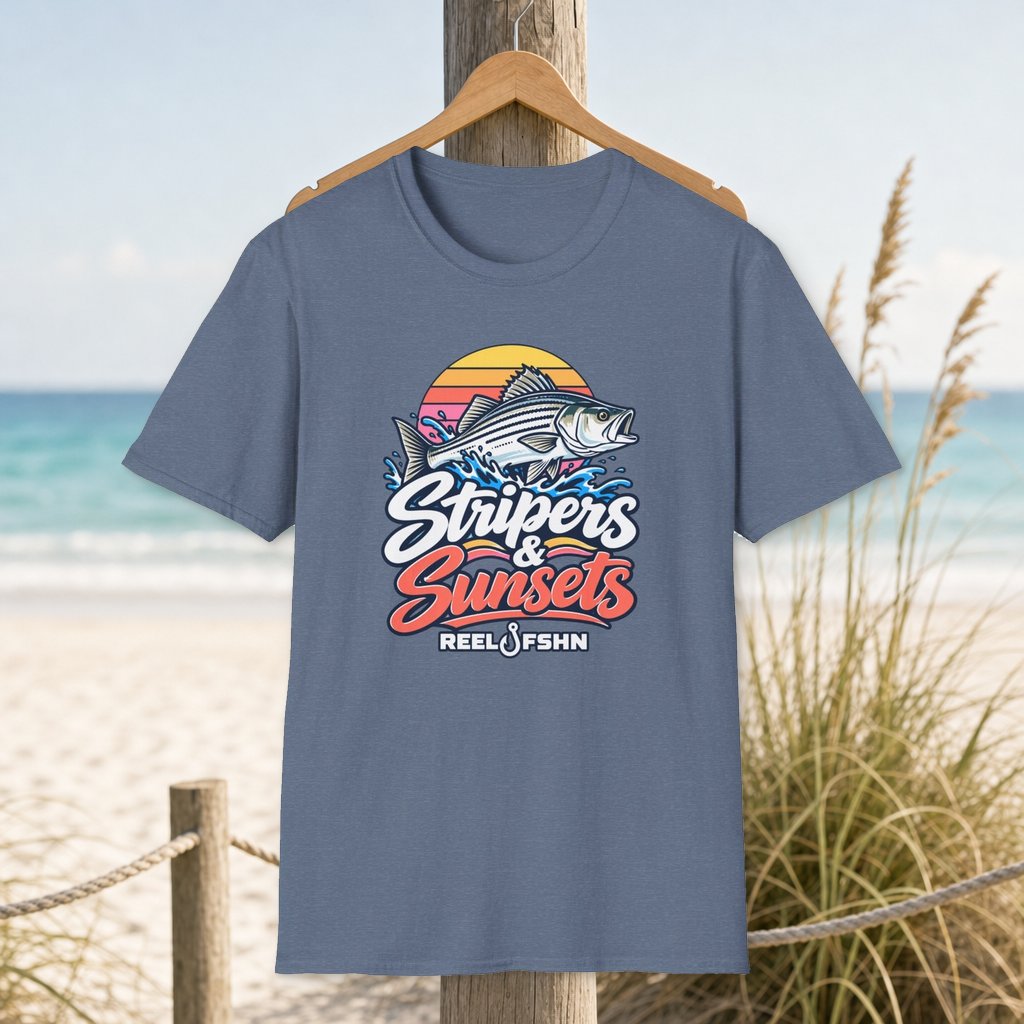 Stripers & Sunsets T-Shirt on a hanger beside a sandy beach and turquoise coastal water