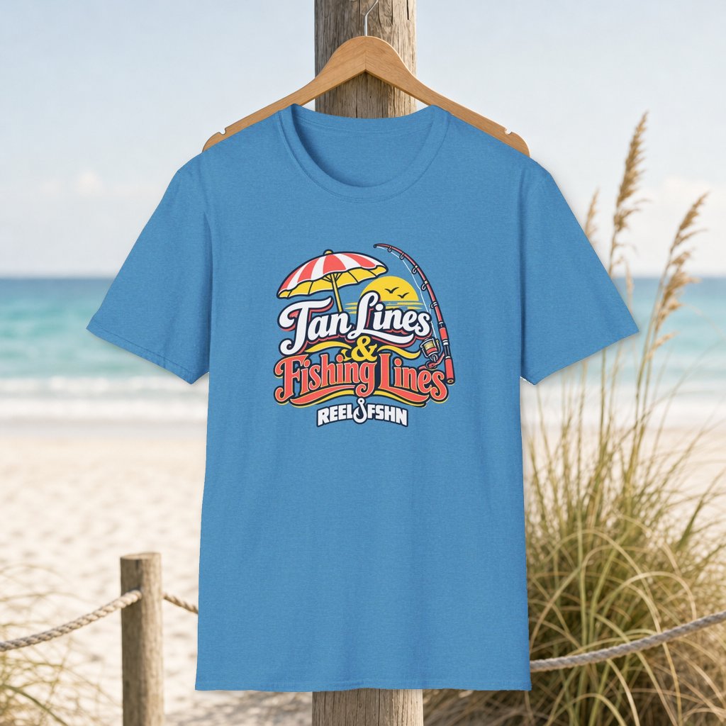 Tan Lines & Fishing Lines T-Shirt on a hanger beside a sandy beach and turquoise coastal water