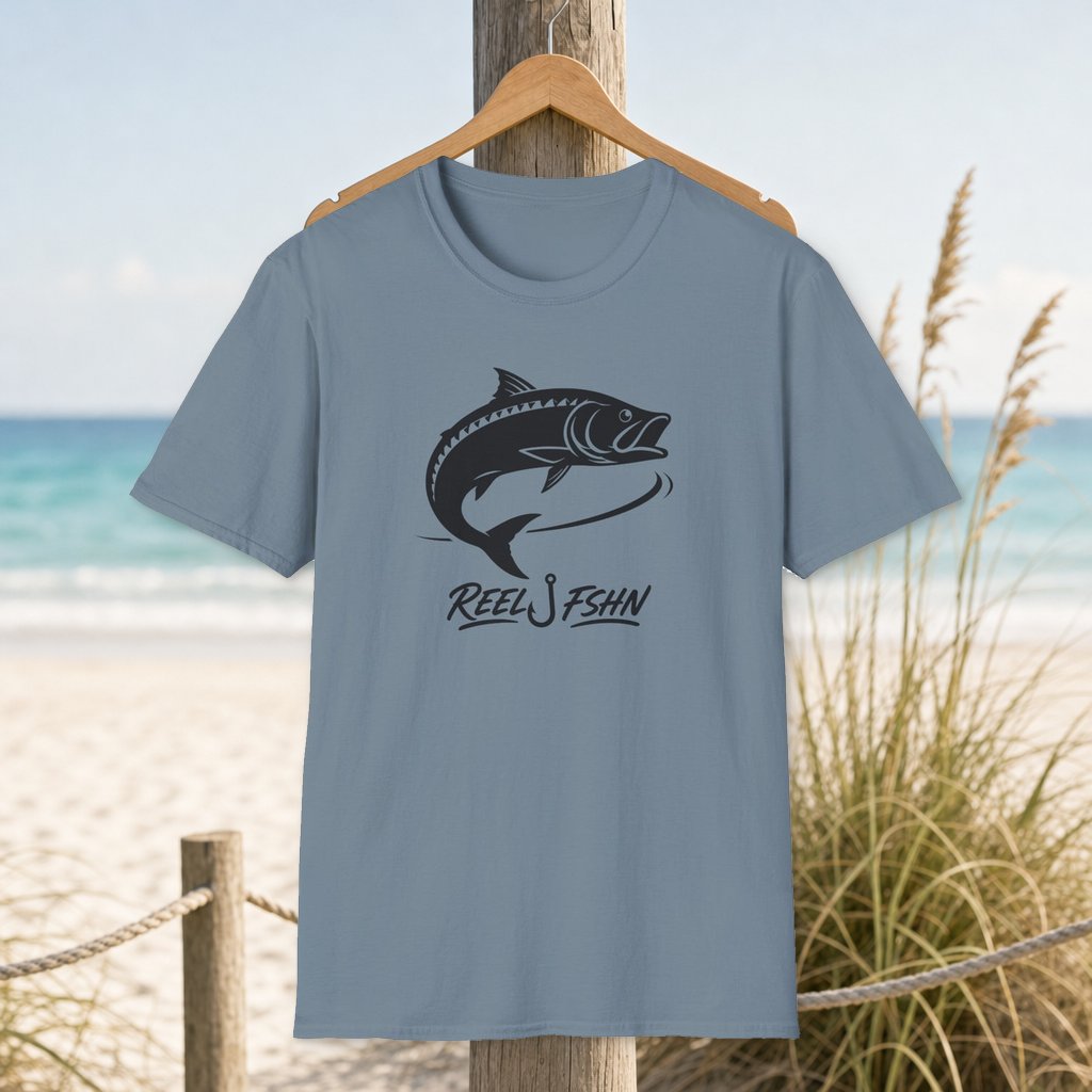 Tarpon Roll Decal T-Shirt on a hanger beside a sandy beach and turquoise coastal water