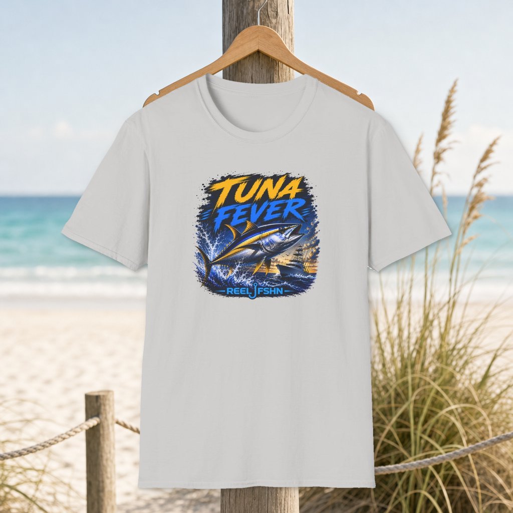 Tuna Fever T-Shirt on a hanger beside a sandy beach and turquoise coastal water