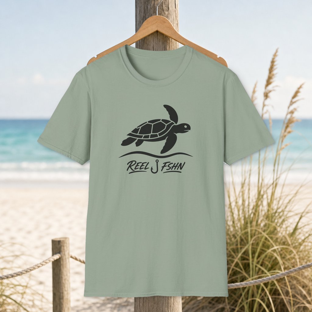 Turtle & Tide with Logo T-Shirt on a hanger beside a sandy beach and turquoise coastal water
