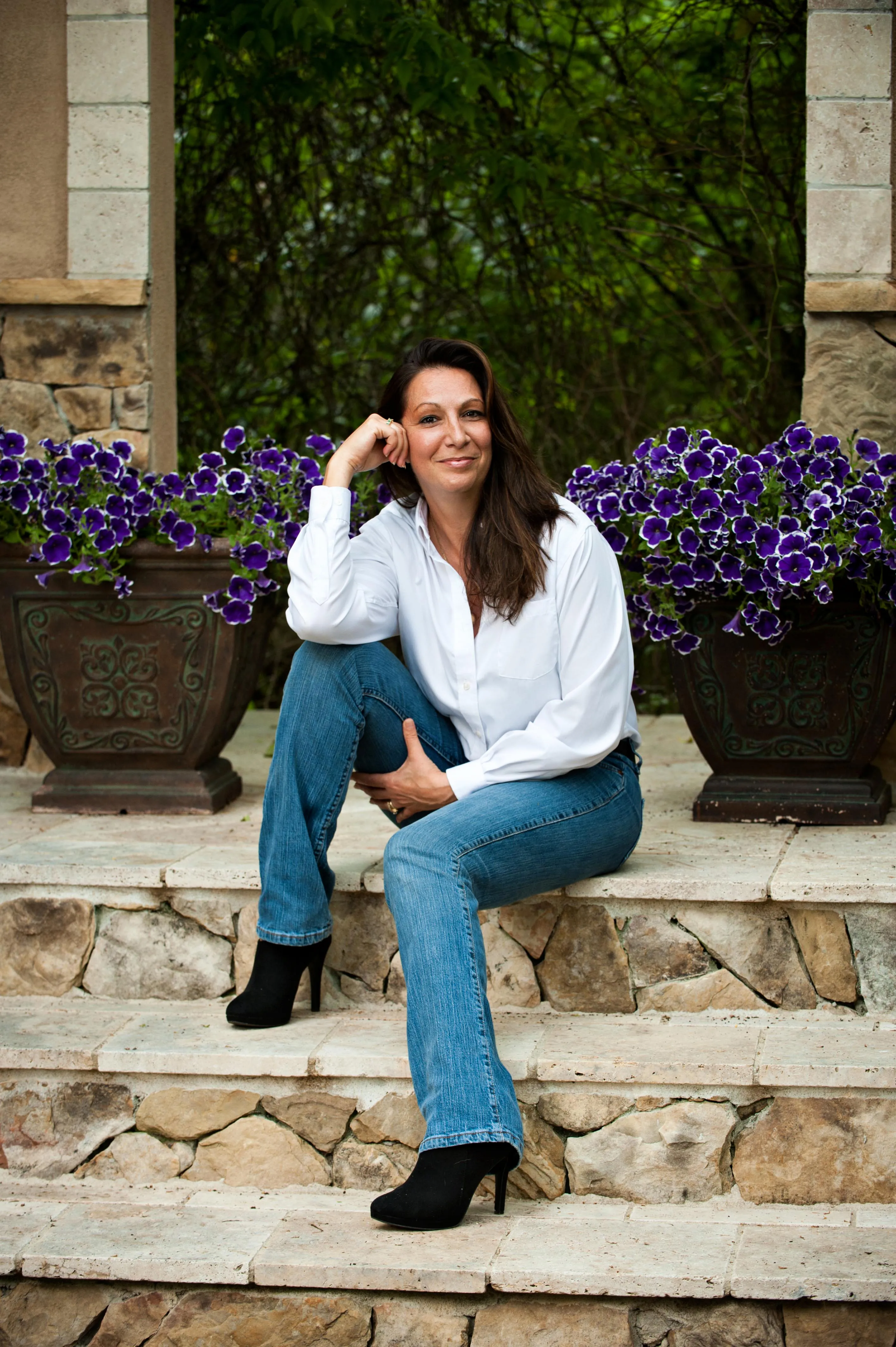 Nicole Myers Henderson seated outdoors among purple flowers