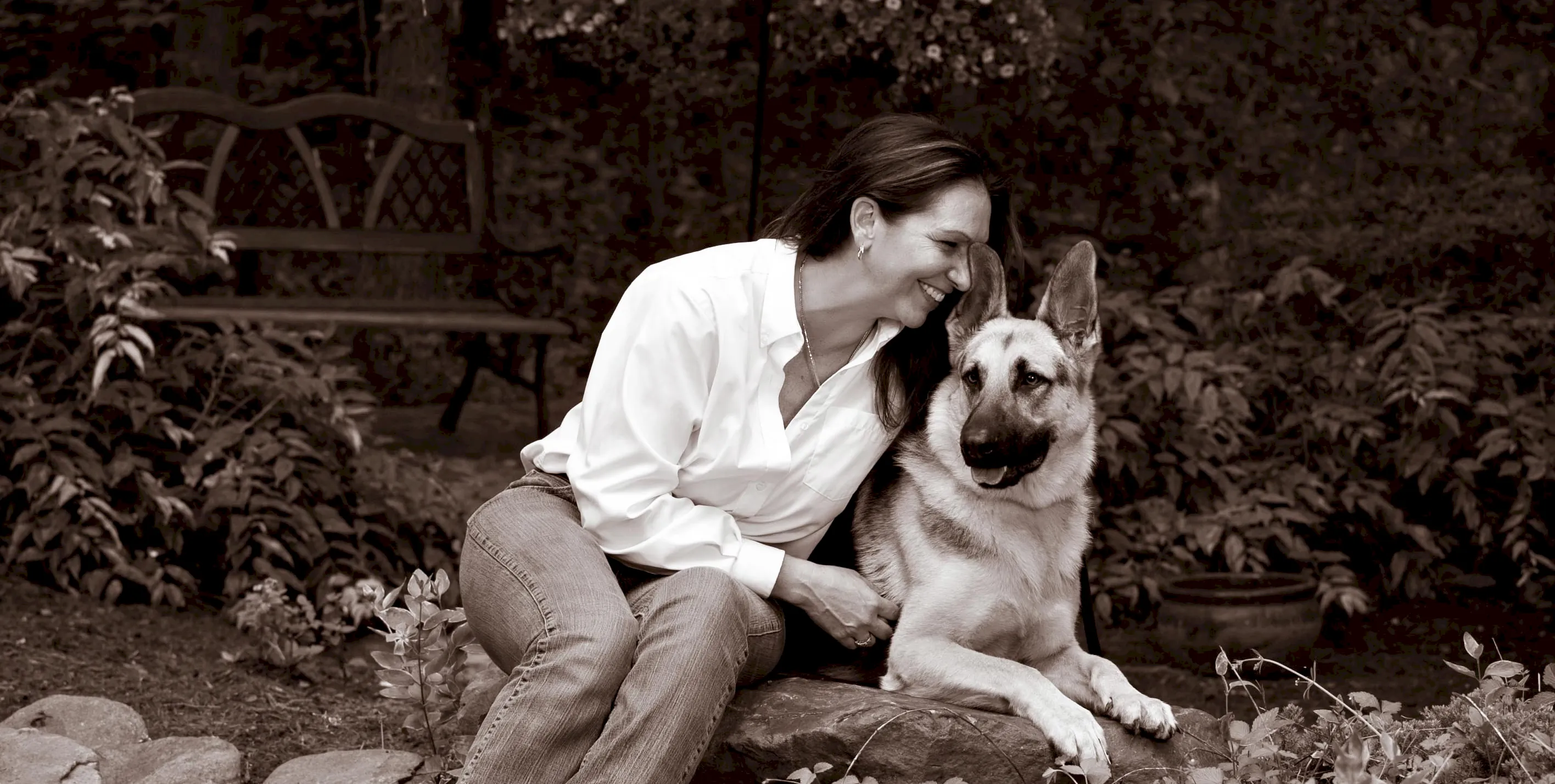 Nicole Myers Henderson seated outdoors with her dog
