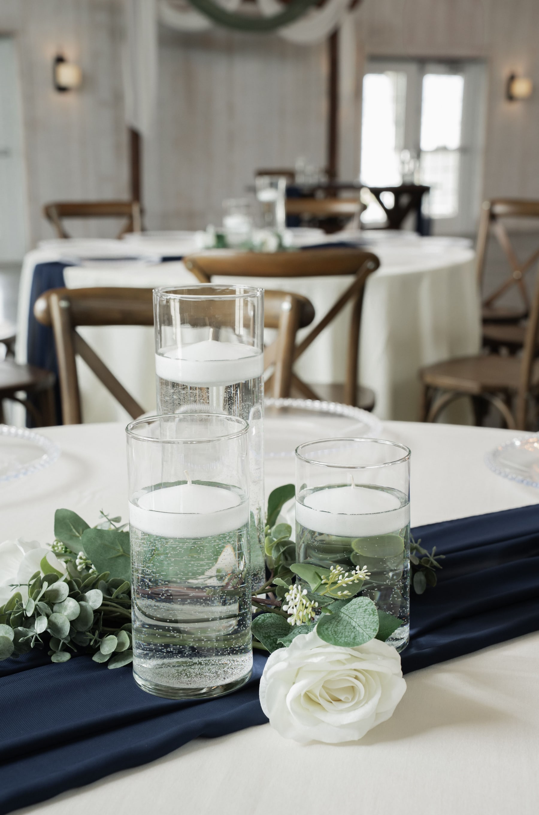 Floating candles in clear glass cylinders on a refined wedding table