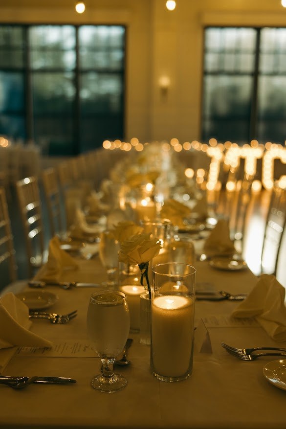 Layered candlelight centerpieces along a table ready for guests