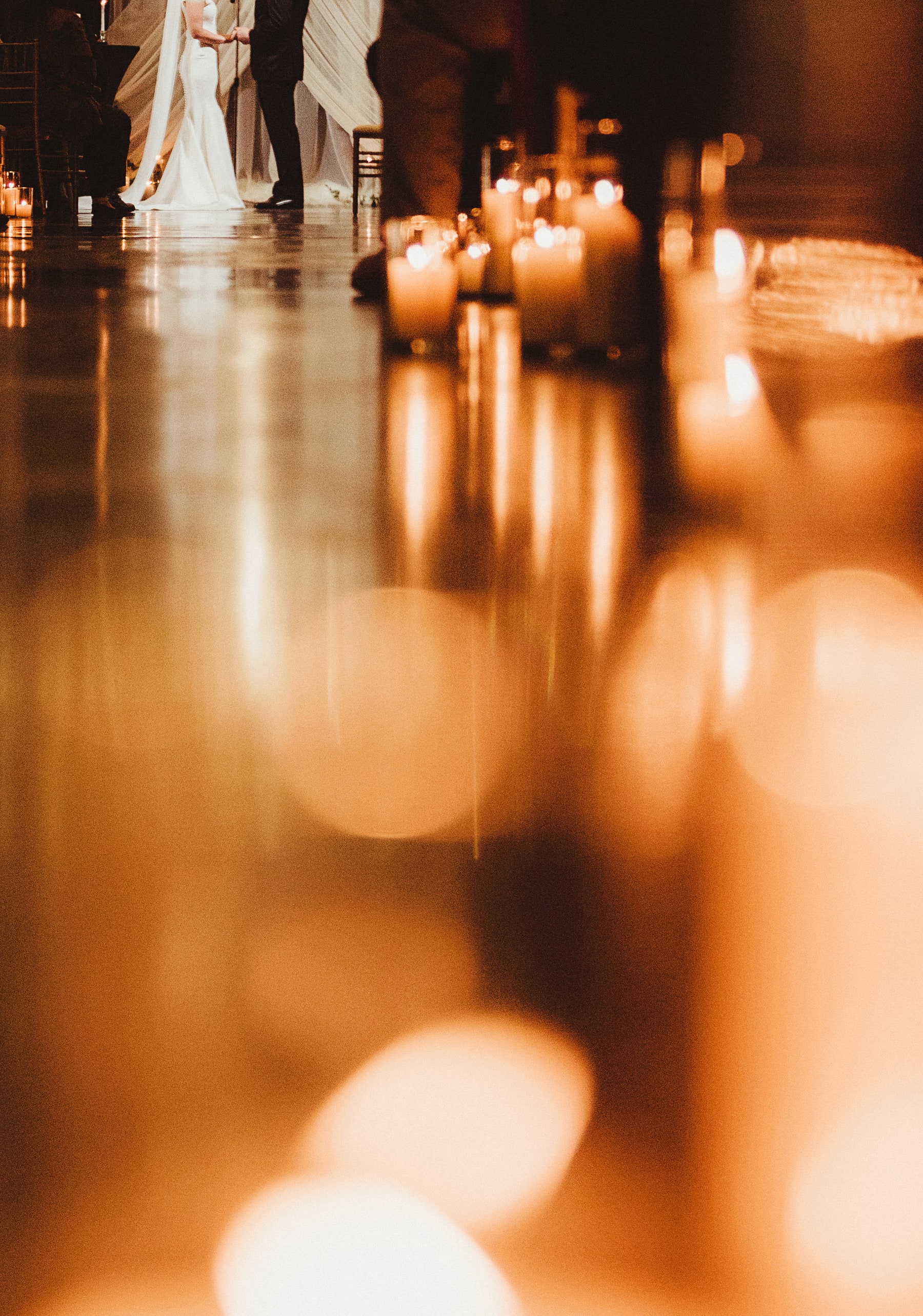 Couple surrounded by a dramatic floor installation of glowing candles